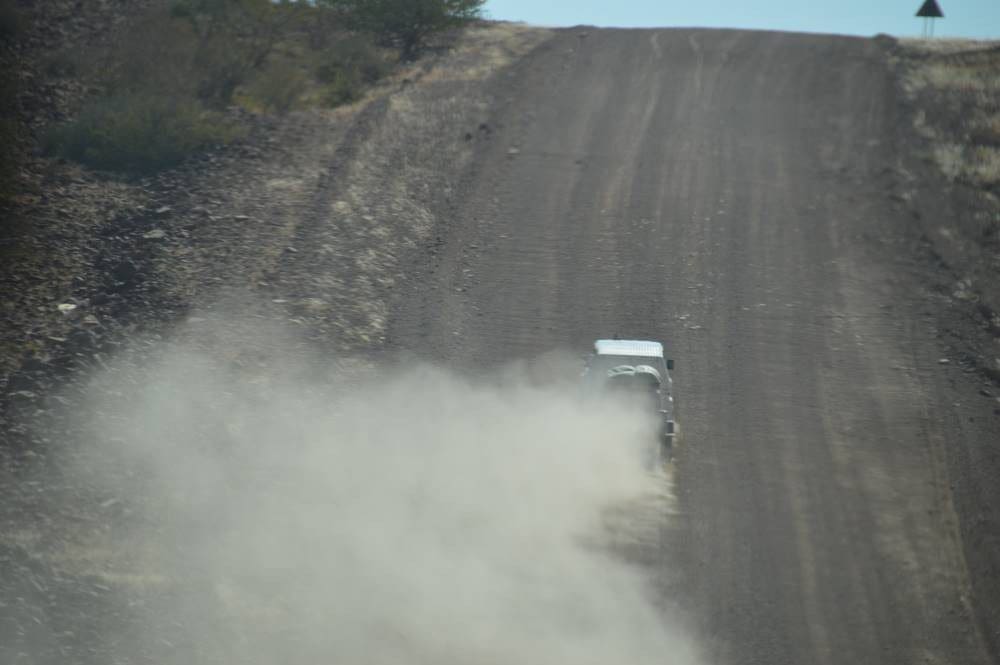 dust clouds evolve on gravel road - Dusty Trails Safaris Namibia & Dusty Car Hire Namibia