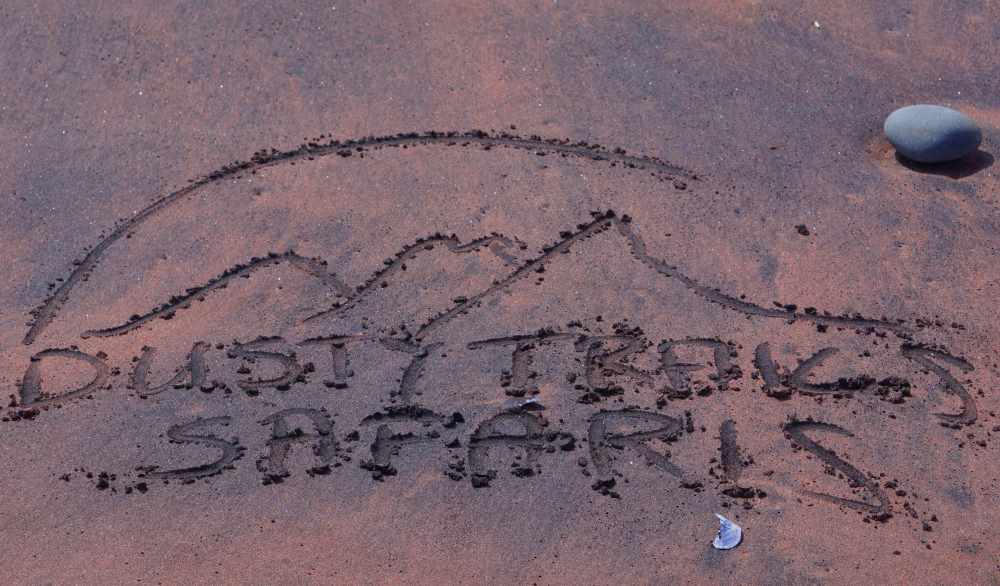 Dusty Trails Safaris Logo in the beach sand at Mile 8
