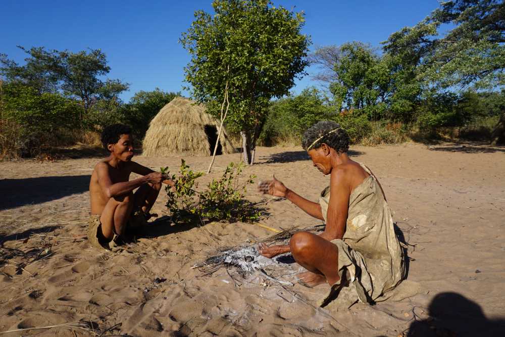 bushmen people eating sandpaper raisins at their village