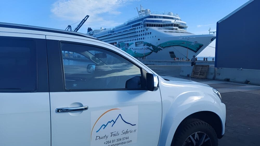 Dusty Trails Safaris rental car in front of a cruise ship - ready to serve a day trip in Namibia