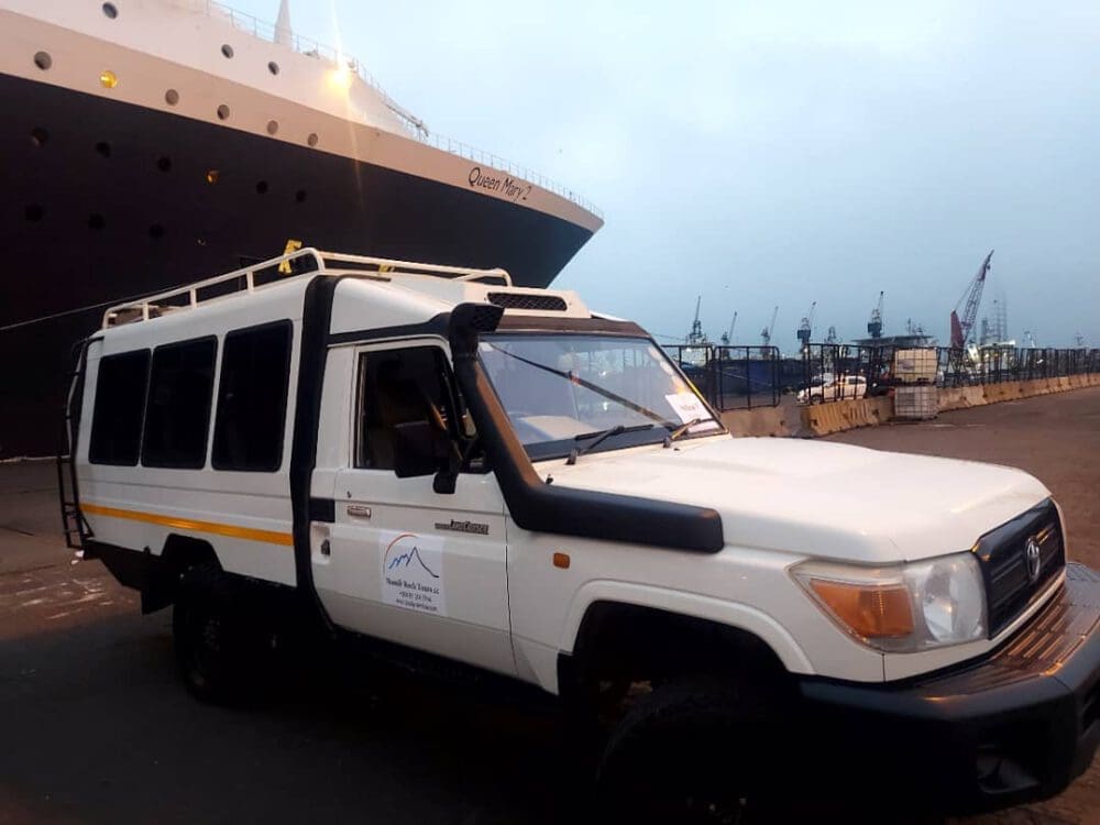 Dusty Trails Safaris 10 seater in front of Queen Mary 2